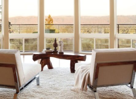 Interior of a house overlooking prairie with large glider windows.