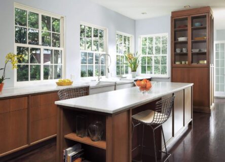 Kitchen interior with walls lined with single hung windows.