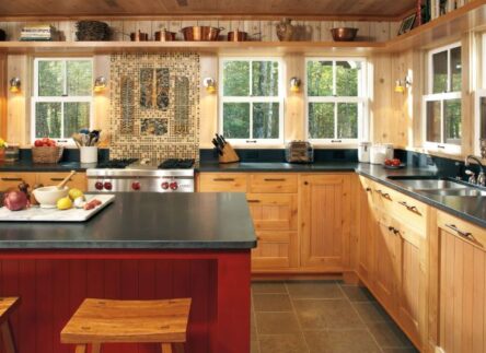 A brown kitchen with many single hung windows on the walls.